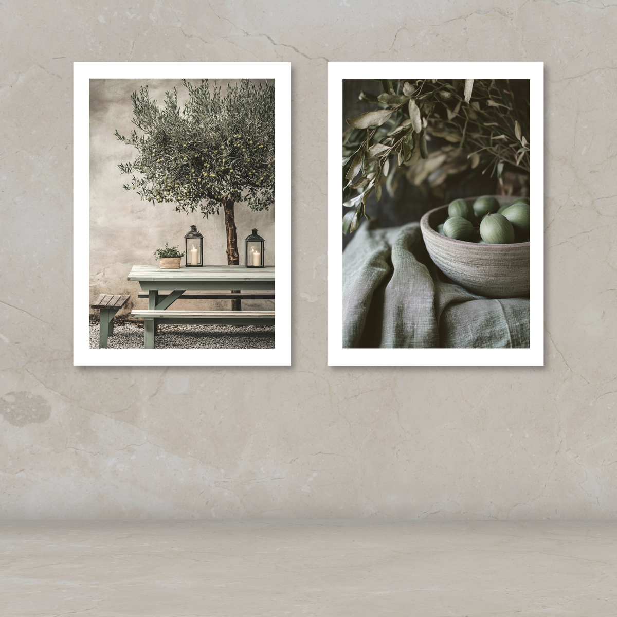 Two framed art prints with white borders displayed side-by-side on a textured beige wall. The left print shows an olive tree on a bench with lanterns, and the right print shows green olives in a bowl with olive branches.