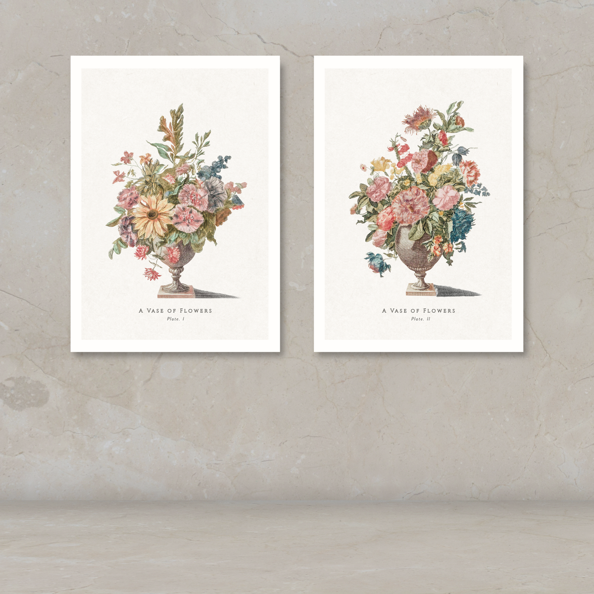 Two framed botanical art prints of flower bouquets in urns, displayed side by side on a textured beige wall above a light floor.